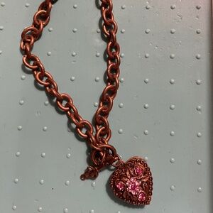 Unmarked bronze coloured heart locket necklace.